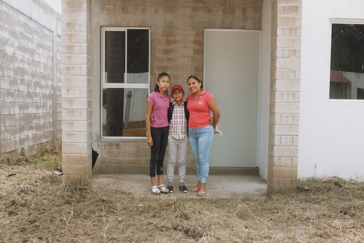 Viviana & her two daughters in front of their new home